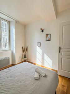 a bedroom with a bed with a pair of towels on it at Les Saints Nico à 5 min Port, Gare & Centre in La Rochelle +25 photos