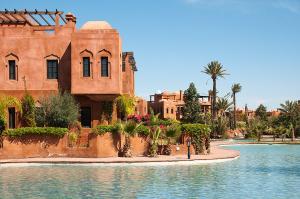 a building with a pool of water in front of a building at Palacio Hôtel Condominium Marrakech in Marrakech
