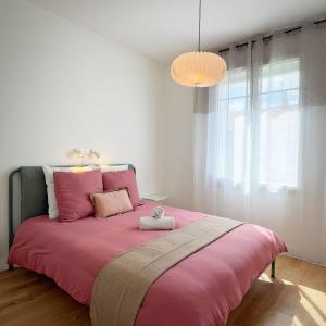 a bedroom with a pink bed with a pink blanket at Maison Du Marché in La Rochelle