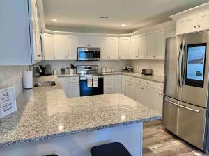 a kitchen with white cabinets and stainless steel appliances at Modern 2bd 2ba - Near I75, No Steps, Free Wifi in Richmond
