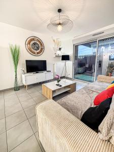 a living room with a couch and a tv at Le Saint Éloi in La Rochelle +5 photos