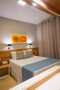 ポソス・デ・カルダスにあるHotel Minas Geraisの青い毛布が掛けられた大きなベッドのある寝室