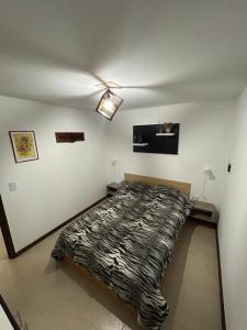 een slaapkamer met een bed met een zebradeken bij El EDEN in Mar de Cobo