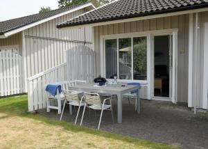 a white table and chairs on a patio at Åhus Havsvillor in Åhus