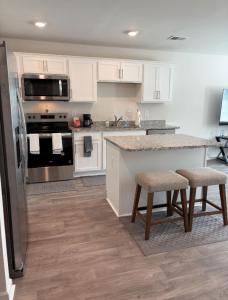 a kitchen with white cabinets and a counter with stools at Wilson Retreat in Wilson