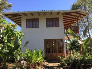 a small white house with a wooden door at Hidden Coast villa Frangipani Ocean & Jungle in Manzanillo +18 photos