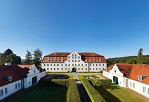 un grand bâtiment blanc avec un toit rouge dans l'établissement Schloss Lautrach, à Lautrach