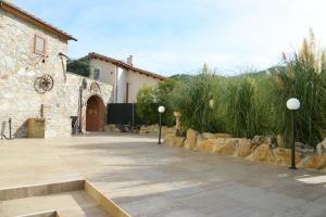 カパンノリにあるVILLA GIOVANNA - Guest House Luccaの石造りの建物と芝生の建物のある中庭