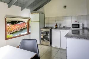 a kitchen with white appliances and a table at BOG Departamento centro - Vista Horizonte in Villa La Angostura +8 photos