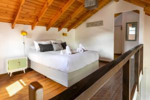 a bedroom with a large white bed and wooden ceilings at BOG Departamento centro - Vista Horizonte in Villa La Angostura