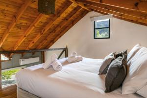 a bedroom with a white bed with towels on it at BOG Departamento centro - Vista Horizonte in Villa La Angostura