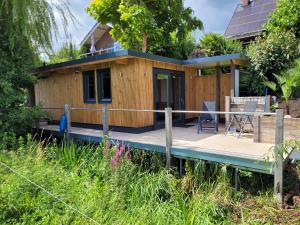 a tiny house on a dock with a porch at Prins van Poederoijen in Poederoijen