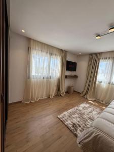 a bedroom with white curtains and a bed and a rug at Modern Studio France ville in Casablanca +1 photo