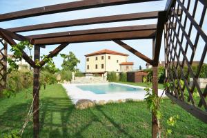 a pool in a garden with a wooden fence at VILLA GIOVANNA - Guest House Lucca in Capannori