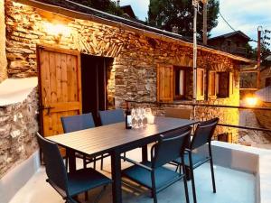 une table et des chaises en bois sur une terrasse dans l'établissement Apartamento en Girona, à Tor