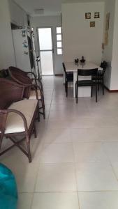 a dining room with a table and chairs and a kitchen at Itacimirim 3 quartos pé na areia in Camaçari