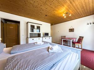 een slaapkamer met twee bedden en een tafel en stoelen bij Landhaus Steibis - Seelekopf in Steibis