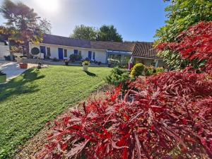 a house with a garden with red plants at Lagalerne in Neuville-du-Poitou