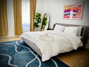 a bedroom with a large white bed with a blue rug at Palais Wieserfeld in Steyr +67 photos