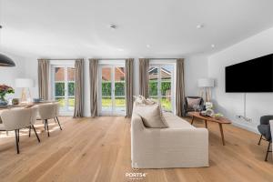 ein Wohnzimmer mit einer weißen Couch und einem Tisch in der Unterkunft Villa Tinnum Sylt in Tinnum + 36 Fotos