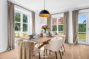 a dining room with a wooden table and chairs at Villa Tinnum Sylt in Tinnum
