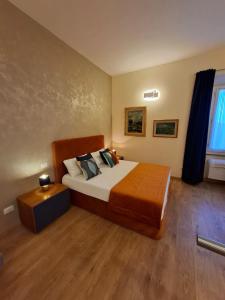 a bedroom with a large bed with a wooden floor at Il Pacchiarotto - Inside the Medieval Walls & Wi-Fi in Casole dʼElsa