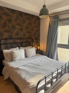 Un dormitorio con una cama grande con una pared de ladrillo. en Studio Zenata Central Park Près de la plage Vue Piscine, en Aïn Harrouda 41 fotos más