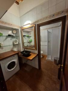 a bathroom with a sink and a washing machine at Il Pacchiarotto - Inside the Medieval Walls & Wi-Fi in Casole dʼElsa +21 photos