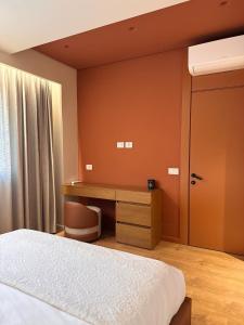 地拉那Luxury Flat In Tirana的一间卧室，配有一张床、一张书桌和一扇窗户