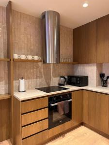 地拉那Luxury Flat In Tirana的配有木制橱柜和炉灶烤箱的厨房