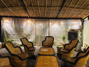 Un porche cubierto con sillas, una mesa y un televisor. en The hut house, en Jāmb