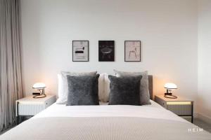a bedroom with a white bed with two lamps on it at Urbano at The Heim Residences in Manchester