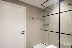 a bathroom with a shower with a glass door at Urbano at The Heim Residences in Manchester +38 photos