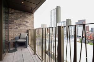 a balcony with a chair and a view of a city at Urbano at The Heim Residences in Manchester