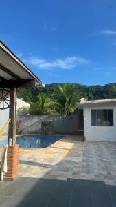ein Haus mit einem Swimmingpool vor dem Haus in der Unterkunft O refúgio perfeito para famílias in Guarujá