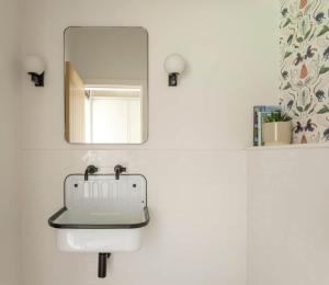 Un baño con un lavabo blanco y un espejo. en Limeworks Hemmel, en Holburn
