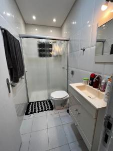 ein Badezimmer mit Dusche, Toilette und Waschbecken in der Unterkunft O refúgio perfeito para famílias in Guarujá