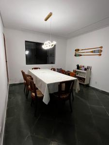 ein Esszimmer mit einem weißen Tisch und Stühlen in der Unterkunft O refúgio perfeito para famílias in Guarujá