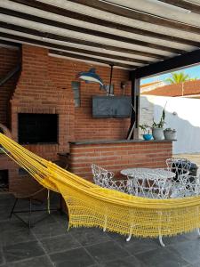 Eine gelbe Hängematte auf einer Terrasse mit Kamin in der Unterkunft O refúgio perfeito para famílias in Guarujá + 10 Fotos