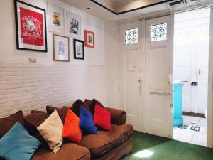 a living room with a brown couch with colorful pillows at Atacama Hostel Backpackers in Santiago +62 photos