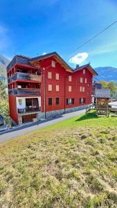 un edificio rojo al costado de una carretera en Casa del Bitto, en Pedesina