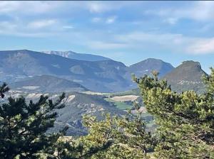 une vue sur une chaîne de montagnes avec des arbres au premier plan dans l'établissement Au gîte de Saint Peyre, à Ribeyret