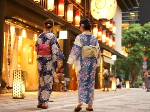 two women in kimonos walking down a street at LiVEMAX Resort Echigo Yuzawa in Yuzawa