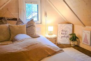 a bedroom with a bed and a window and a sign at Wöschhüsli mit Sauna, Alpenruhe nahe Bodensee in Rheineck