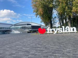 a red heart sitting in front of a building at De Eikenloft in Heerenveen