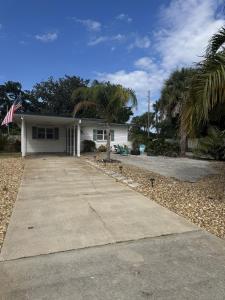 una casa blanca con una palmera delante en Cozy Jax Beach Pool Home!, en Jacksonville Beach