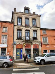 a building with cars parked in front of it at cocon beaujolais in Anse