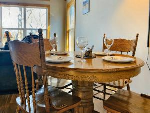 ein Holztisch mit Tellern und Weingläsern darauf in der Unterkunft Oak Tree cabin near the Shenandoah River in Oak Hill