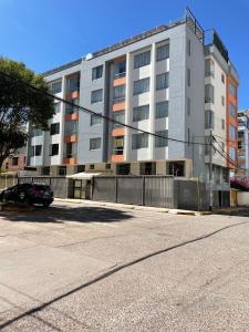 a large white building with a car parked in front of it at Terrazas Cusco in Cusco