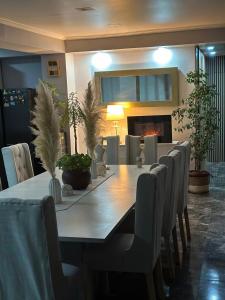 a dining room table with chairs and a fireplace at Spa la casona de pirque in Pirque